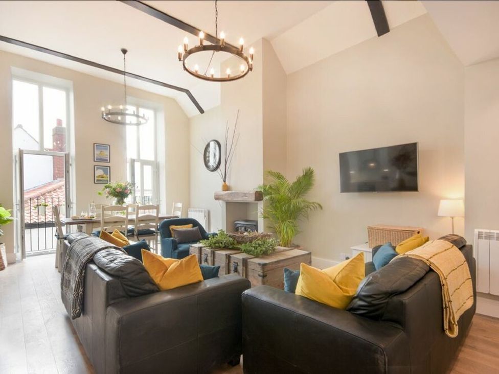 A living room with a sofa and television at Juniper Cottage in 