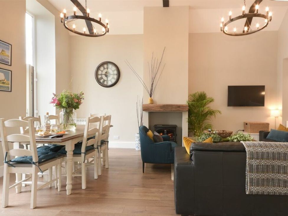 A living room with a dining area and a fireplace at Juniper Cottage