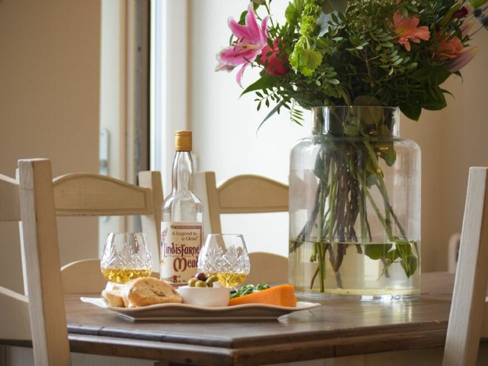 A dining room table with food and drinks at Juniper Cottage