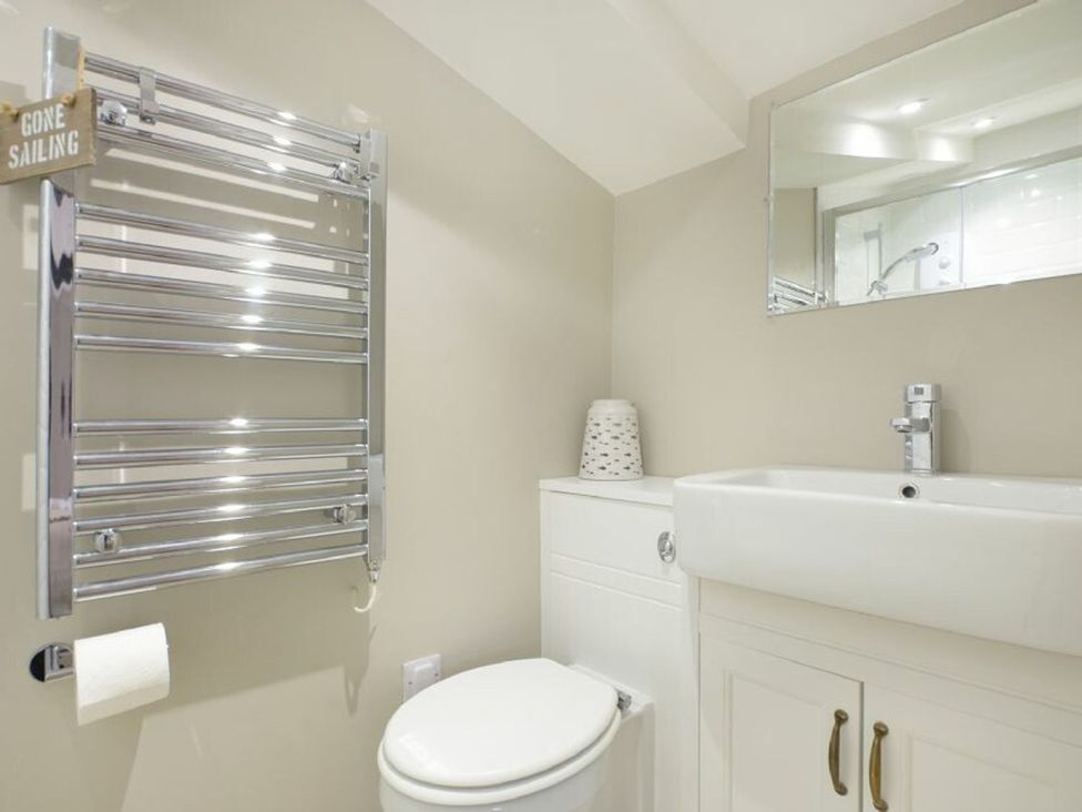 A bathroom with a sink, toilet, and towel rail at Juniper Cottage