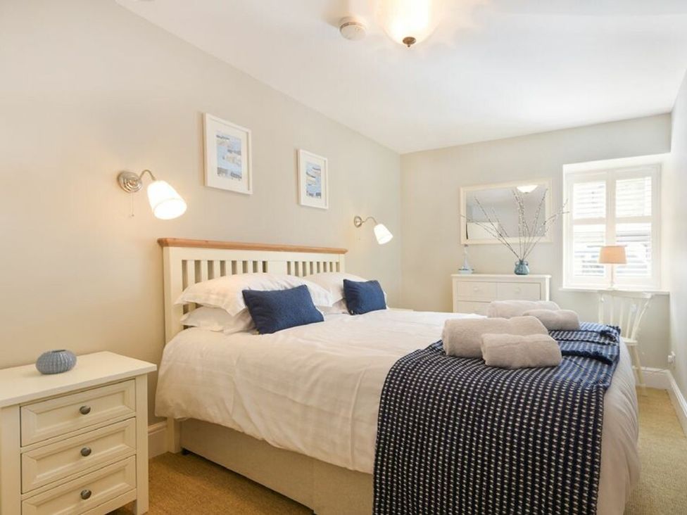 A bedroom with a bed and nightstand at Juniper Cottage