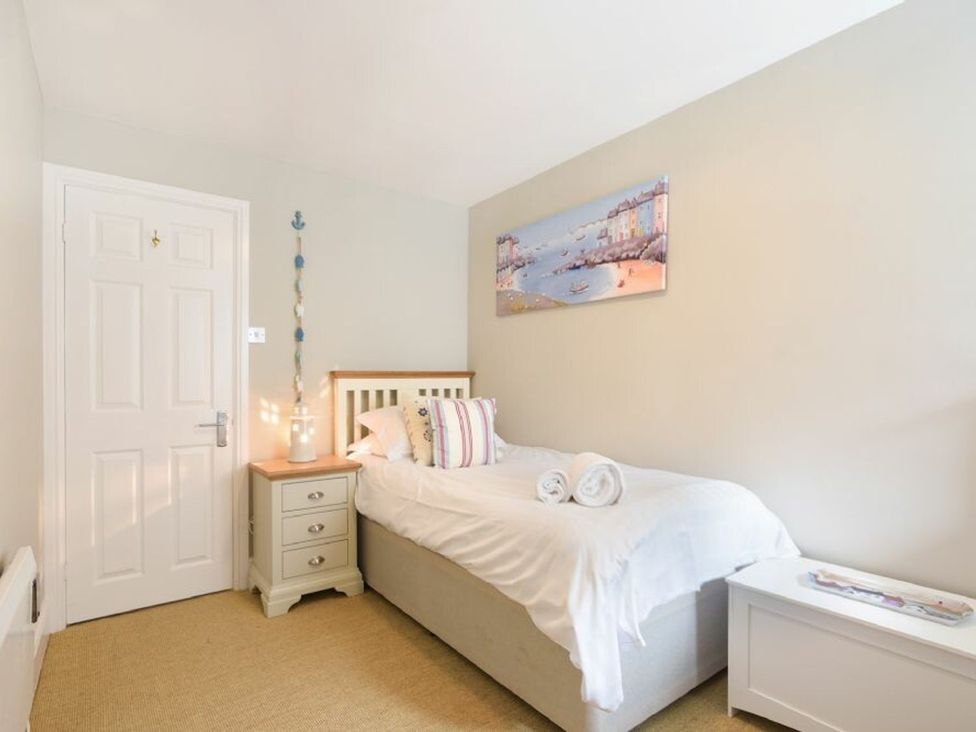 A bedroom with a single bed and bedside table at Juniper Cottage