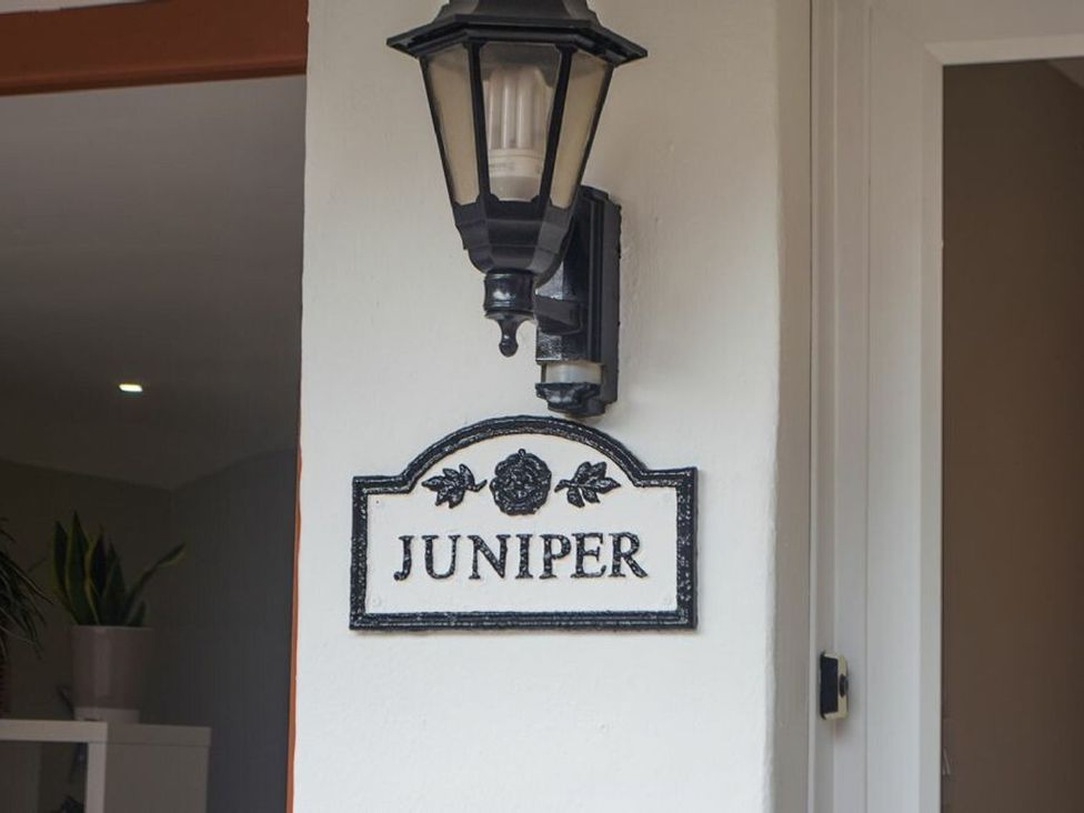 A nameplate with Juniper on it and a light fixture at Juniper Cottage in 