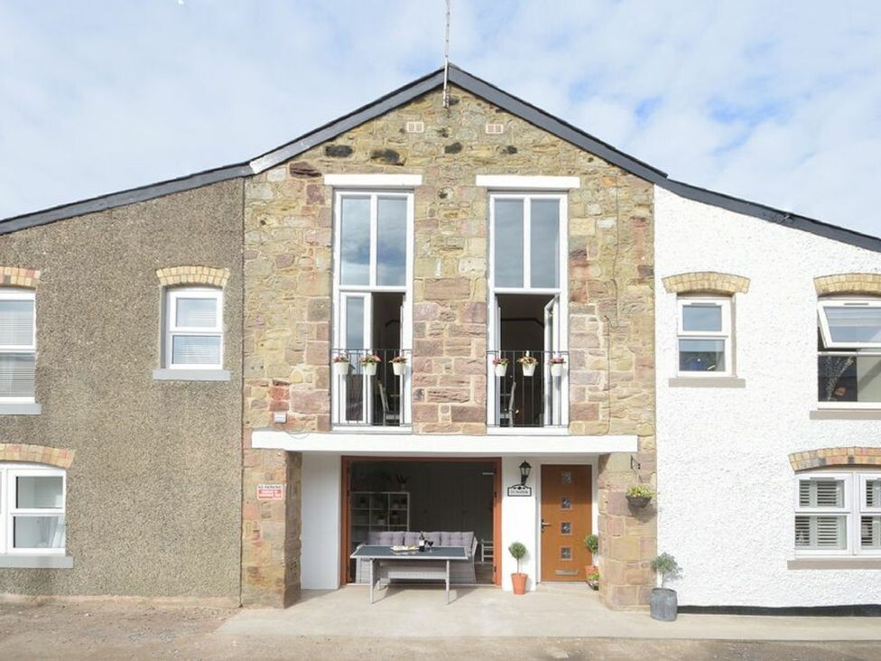 An outdoor view of a building with a balcony at Juniper Cottage in 