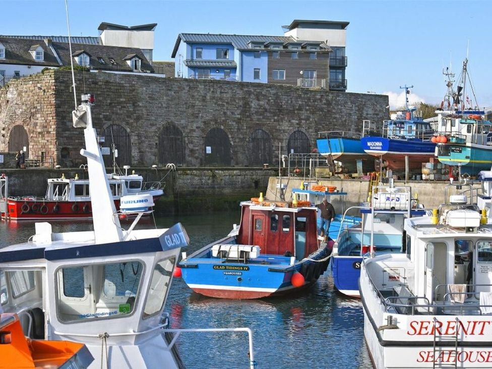 Boats docked at a harbor with buildings in the background at Juniper Cottage in 