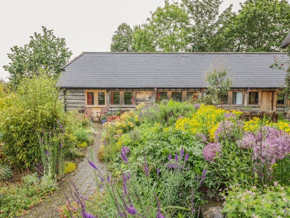 A garden with flowers and a building at Ryepiece in Stratford-upon-Avon