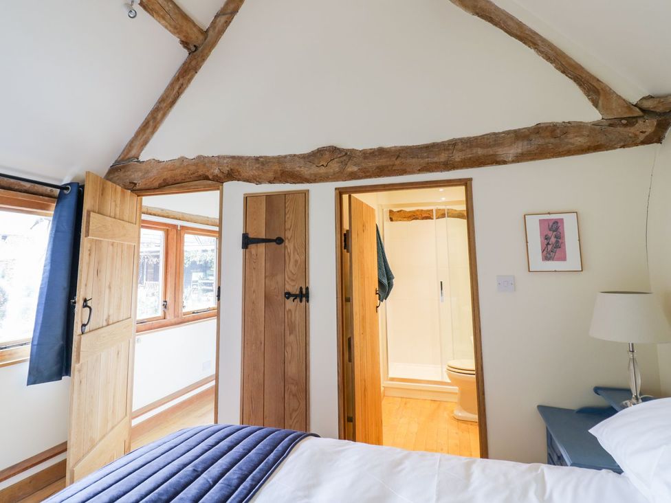 A bedroom with a bed and an adjoining bathroom at Ryepiece in Stratford-upon-Avon