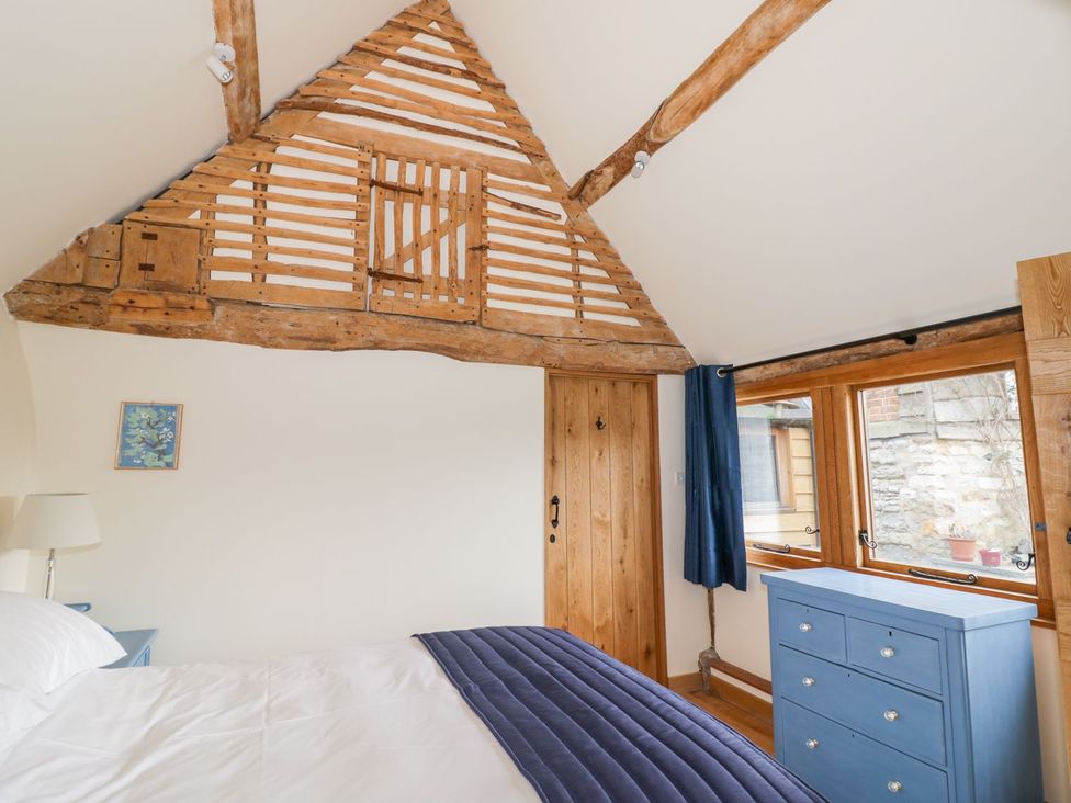 A bedroom with a bed and a blue wardrobe at Ryepiece in Stratford-upon-Avon