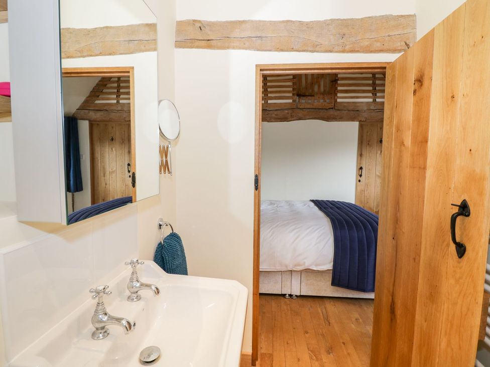 A bathroom with a sink and door leading to a bedroom at Ryepiece Stratford-upon-Avon