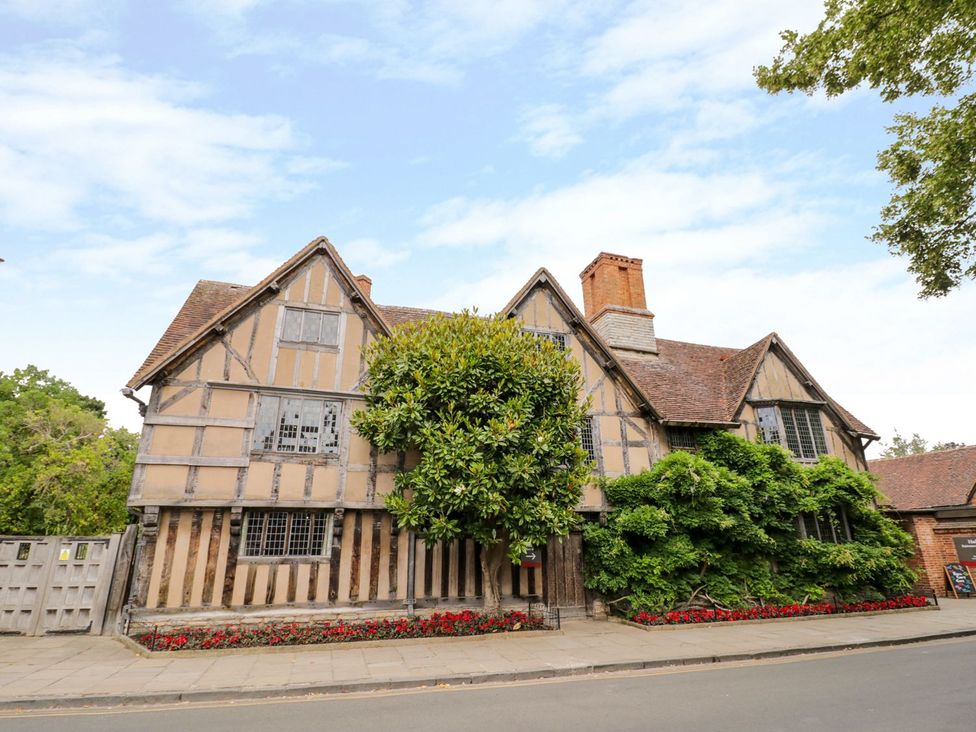 A historic house with a tree and flowers outside at Ryepiece in Stratford-upon-Avon