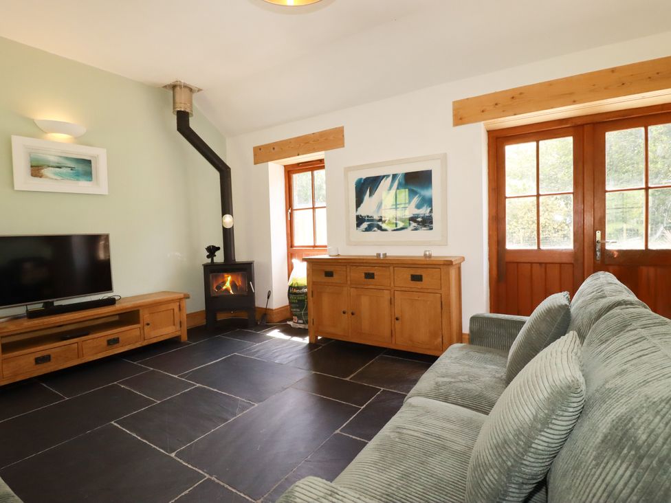 A living room with a sofa and television at Little Trethellan in Trethellan near Lanner