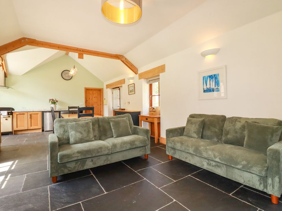 A living room with two sofas and a table at Little Trethellan in Trethellan near Lanner