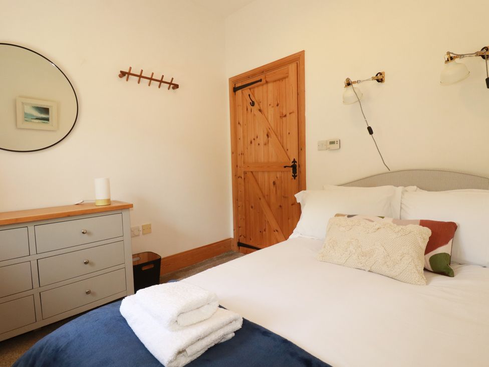 A bedroom with a bed and dresser at Little Trethellan in Trethellan near Lanner