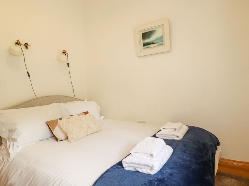 A bedroom with a bed and bedside lamps at Little Trethellan near Lanner