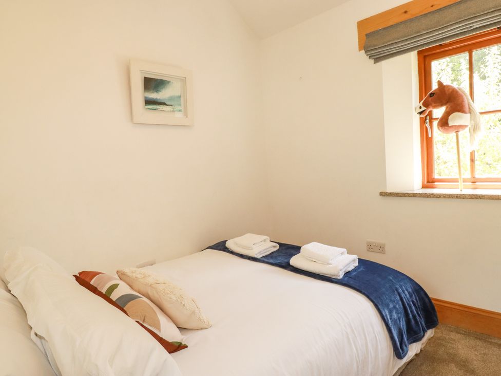 A bedroom with a bed and towels at Little Trethellan in Trethellan near Lanner