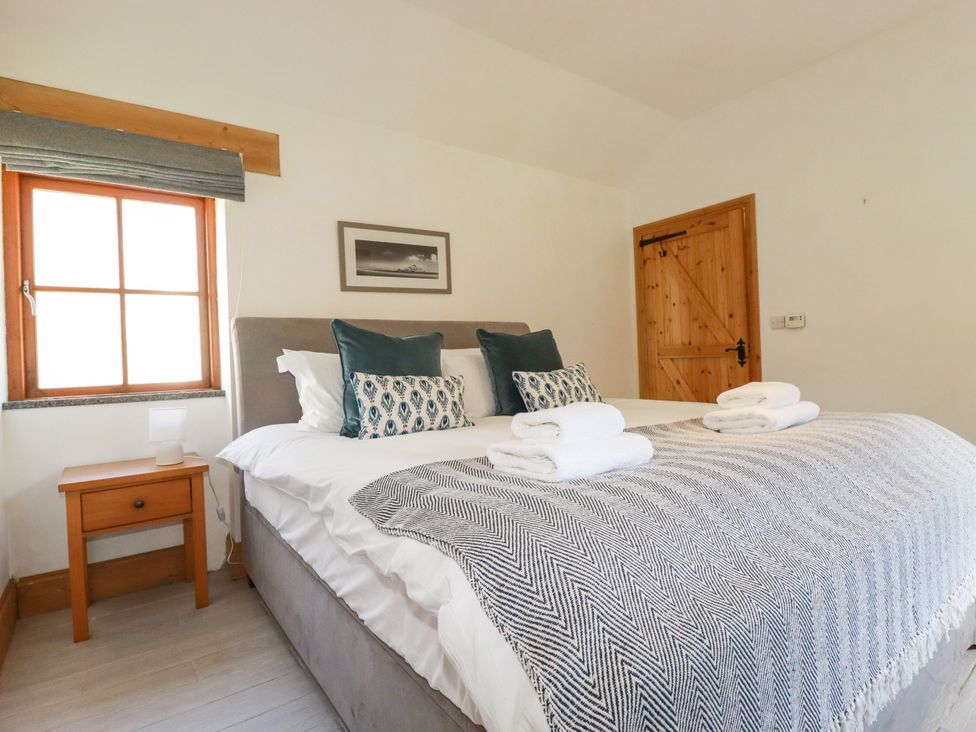 A bedroom with a double bed and bedside table at Little Trethellan in Trethellan near Lanner