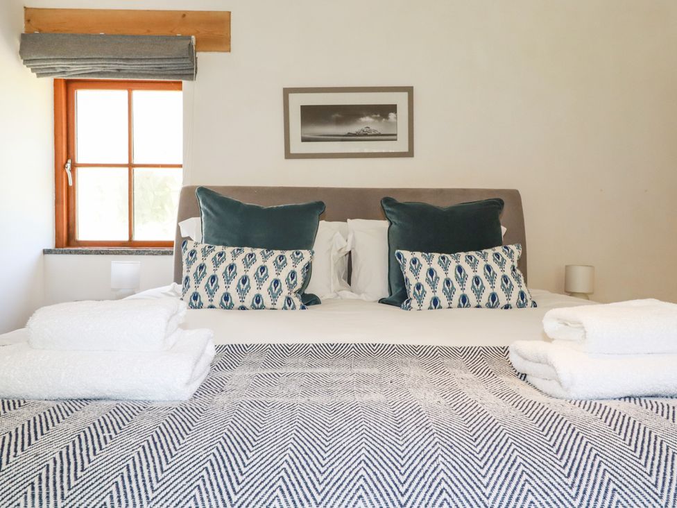 A bedroom with a bed and pillows at Little Trethellan in Trethellan near Lanner
