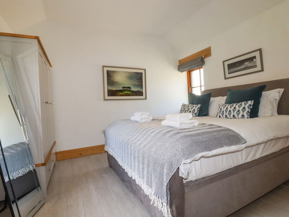 A bedroom with a bed and wardrobe at Little Trethellan in Trethellan near Lanner