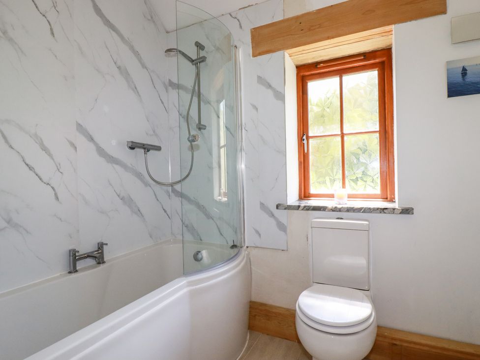 A bathroom with a bathtub and shower at Little Trethellan in Trethellan near Lanner