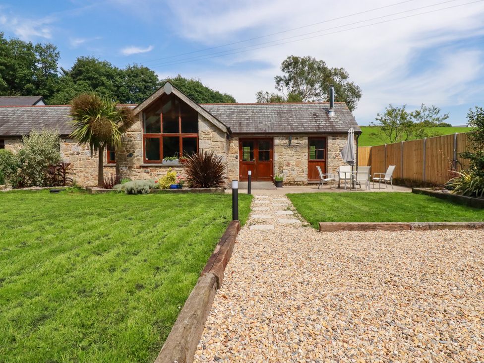 An outdoor area with a house, patio furniture and lawn at Little Trethellan in Trethellan near Lanner