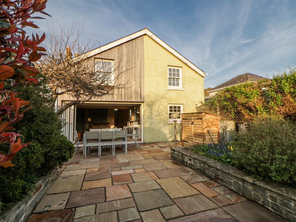 A house with a patio and outdoor dining furniture at Awelon Y Mor in Aberaeron
