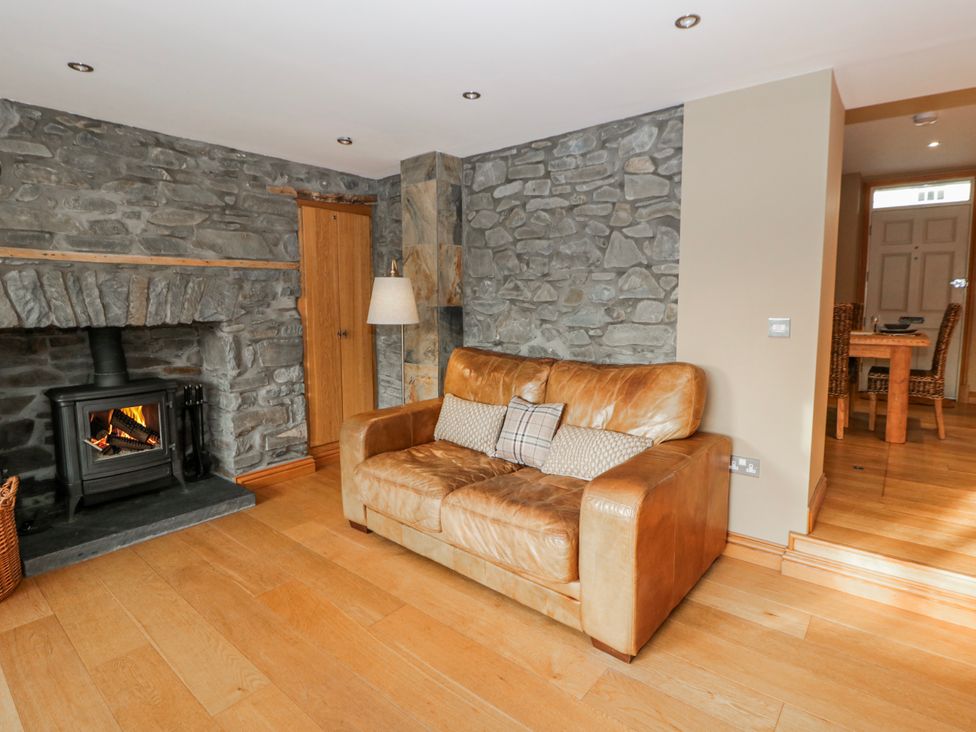 A living room with a sofa and fireplace at Awelon Y Mor in Aberaeron