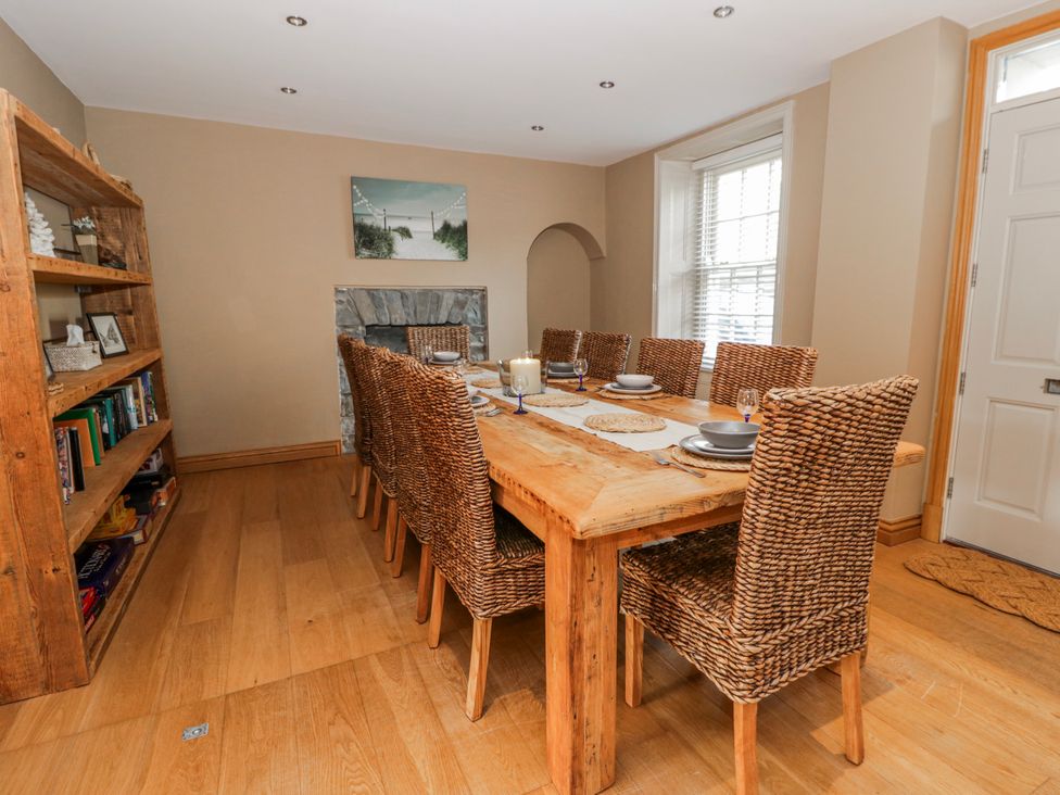 A dining room with a large table and chairs at Awelon Y Mor Aberaeron