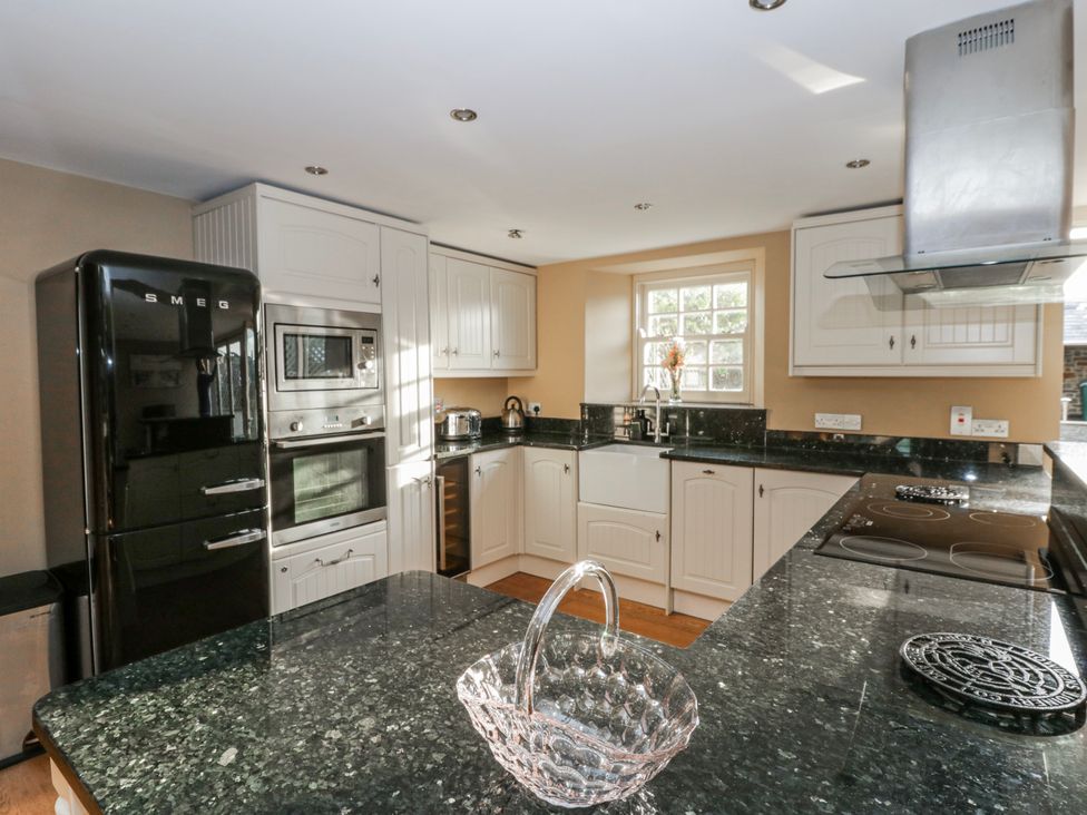 A kitchen with black appliances and granite countertops at Awelon Y Mor in Aberaeron