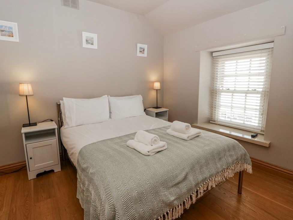 A bedroom with a bed and bedside tables at Awelon Y Mor in Aberaeron