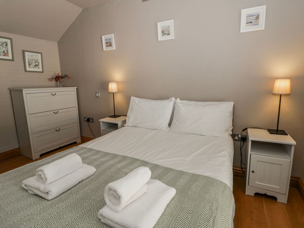 A bedroom with a bed and nightstands at Awelon Y Mor in Aberaeron