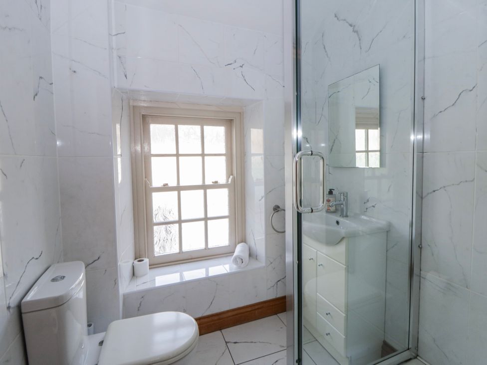 A bathroom with a shower, toilet, and sink at Awelon Y Mor in Aberaeron