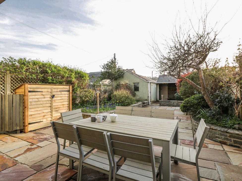 A garden with a table and chairs at Awelon Y Mor in Aberaeron