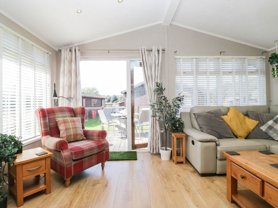 A snug with seating and a view of the outdoor area at South Lakeland Lodge. No. 46 Gressingham near Carnforth