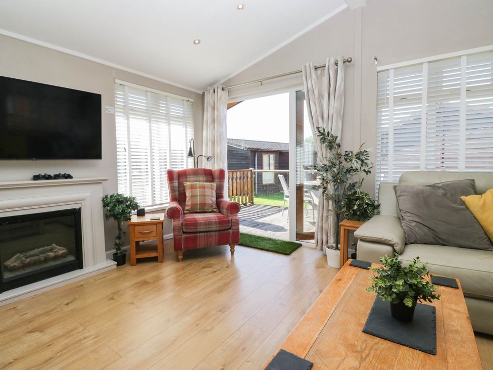 A living room with a television and chair at South Lakeland Lodge. No. 46 Gressingham near Carnforth