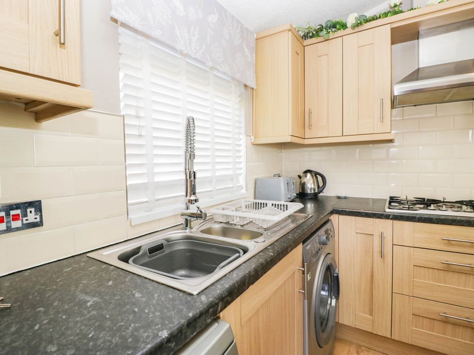 A kitchen with sink and washing machine at South Lakeland Lodge. No. 46 Gressingham near Carnforth