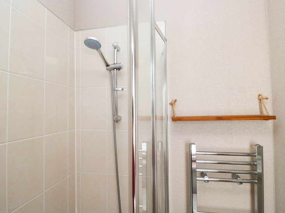 A shower area with a glass door and towel rail at South lakeland Lodge. No. 46 Gressingham near Carnforth