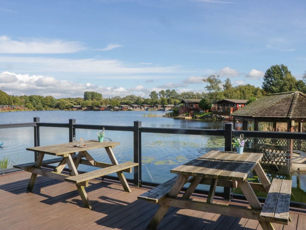 A seating area overlooking a lake at South Lakeland Lodge No. 46 Gressingham near Carnforth