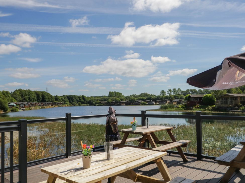 An outdoor seating area near a lake at South Lakeland Lodge. No. 46 Gressingham near Carnforth