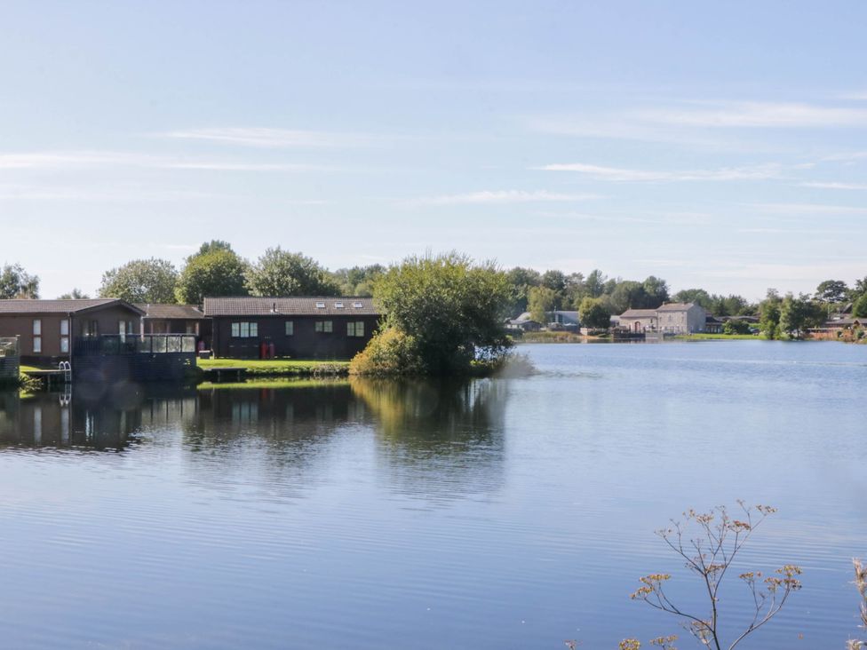 A view of buildings by a lake at South Lakeland Lodge. No. 46 Gressingham near Carnforth