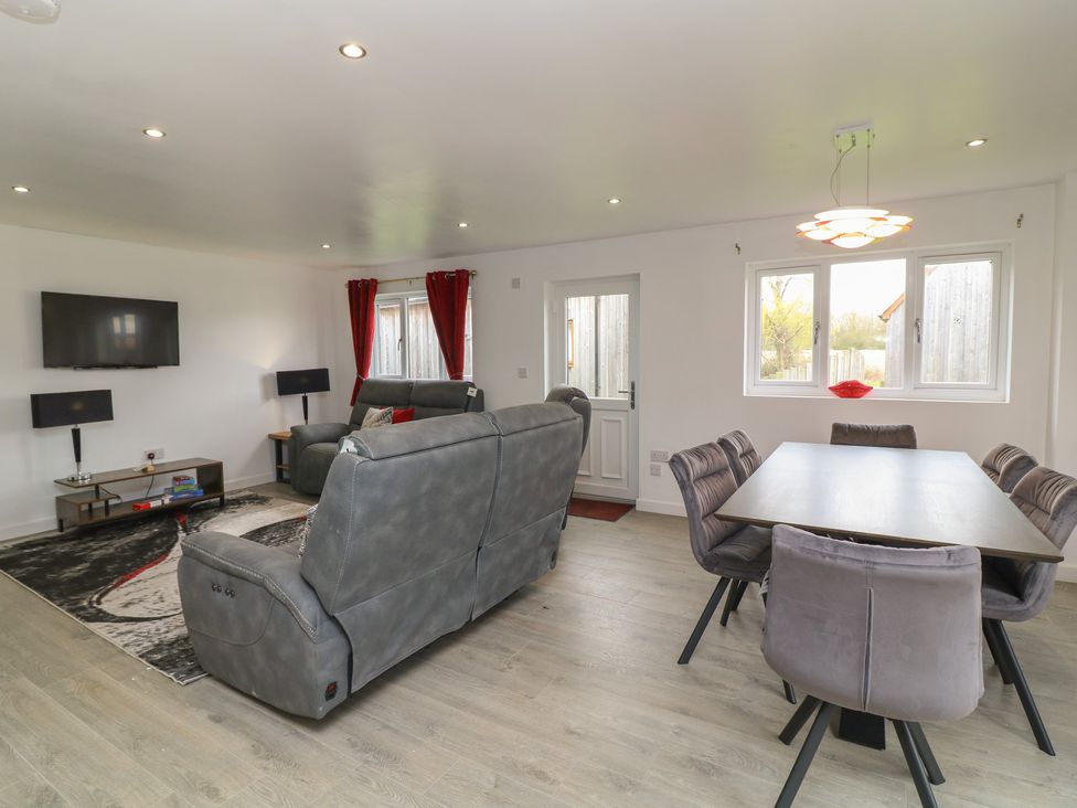 A living room with a sofa and dining area at Ruby Red in Brigg