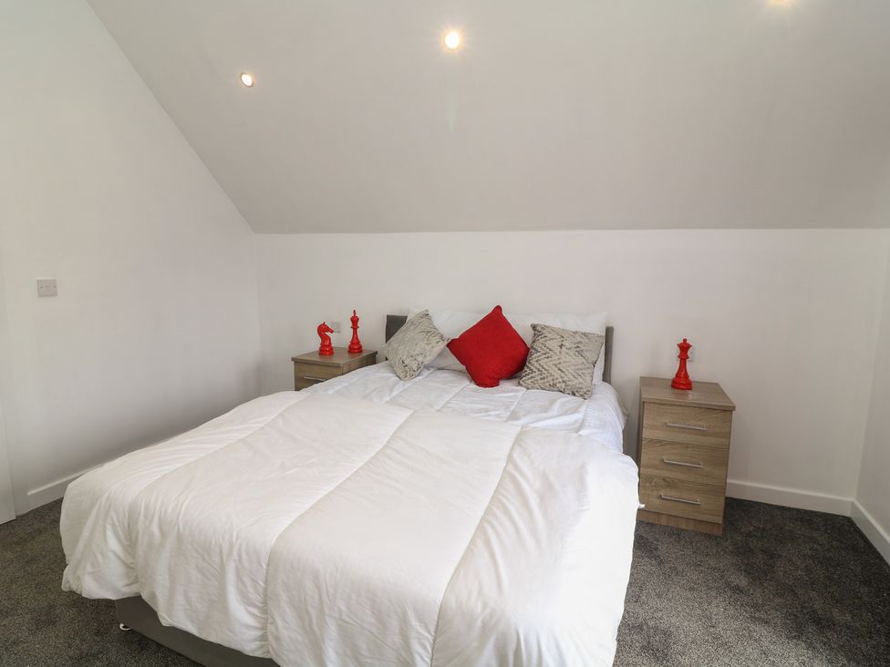 A bedroom with a bed and nightstands at Ruby Red in Brigg