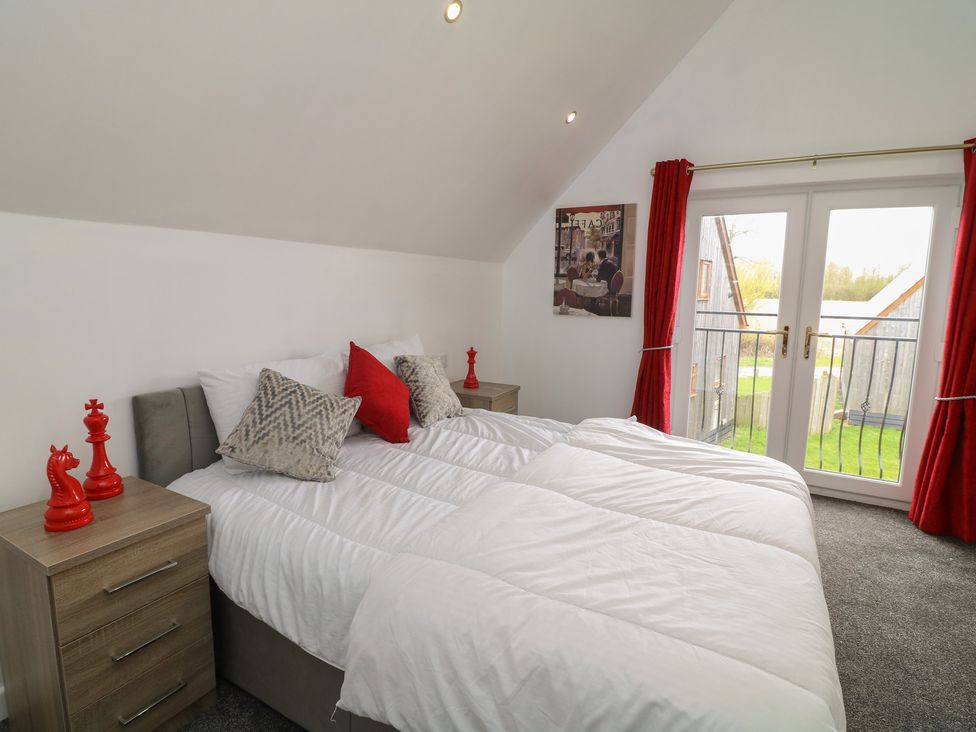 A bedroom with a bed and nightstands at Ruby Red in Brigg