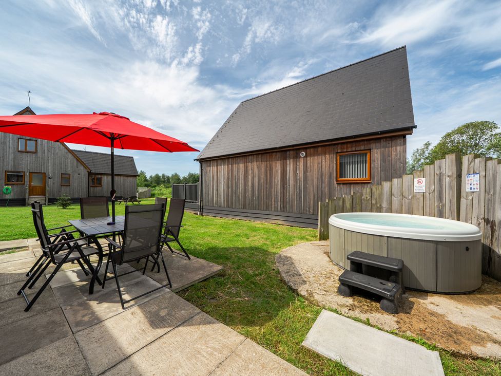 An outdoor area with a table and chairs under an umbrella at Ruby Red near Brigg