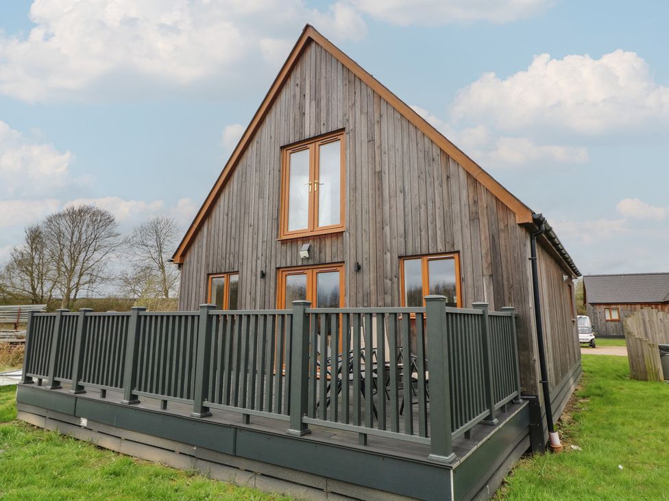 An outdoor view of a house with a deck at Pumpkin Lodge in Brigg