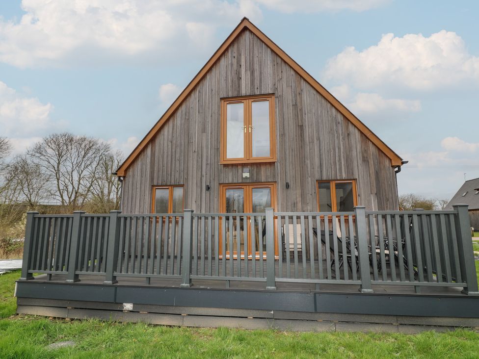 A house with a deck and windows at Pumpkin Lodge in Brigg