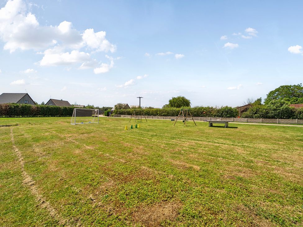 An outdoor area with a goal post, swing set, and traffic cones at Pumpkin Lodge near Brigg