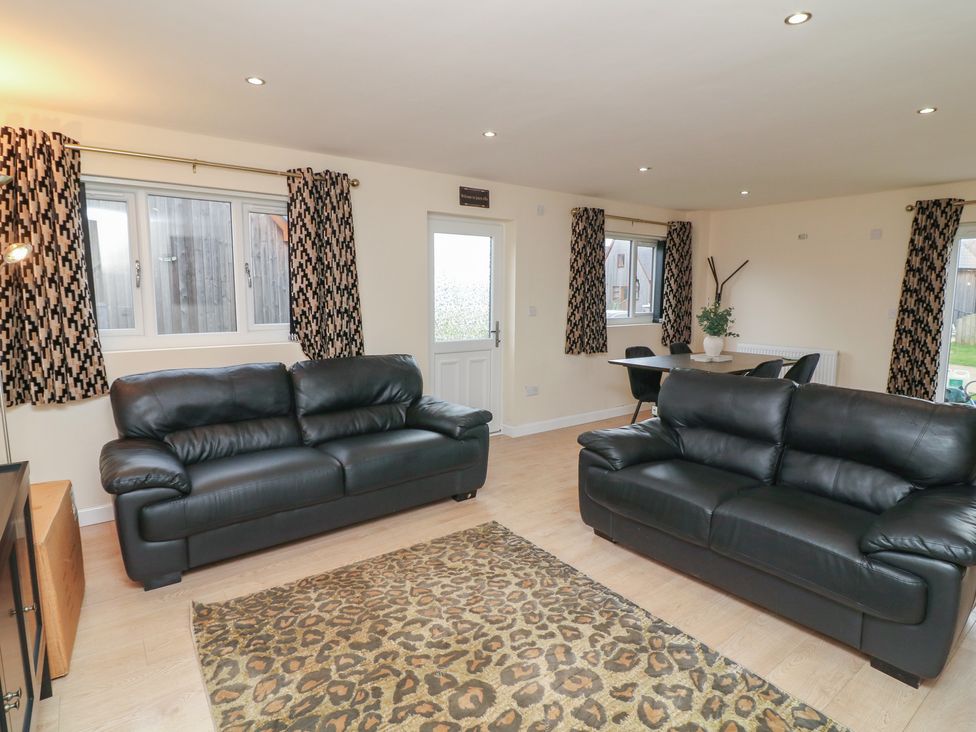 A living room with sofas and a table at Poker Lodge in Brigg