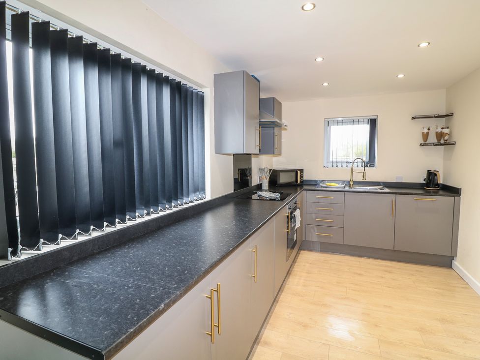 A kitchen with cabinets and a microwave at Poker Lodge in Brigg