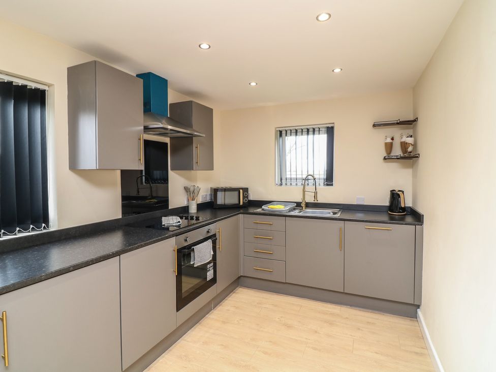 A kitchen with cabinets and appliances at Poker Lodge in Brigg