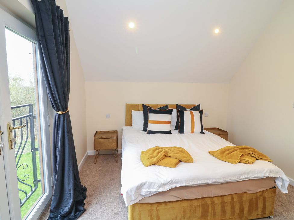 A bedroom with a bed and curtains at Poker Lodge in Brigg